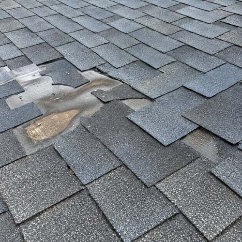 Roof shingles showing wear and a repaired section, found during a Columbus, Ohio home inspection