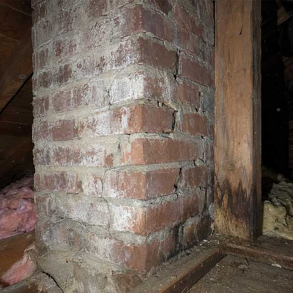Cracked mortar and deteriorated masonry on a chimney chase found during an attic inspection in Columbus, Ohio