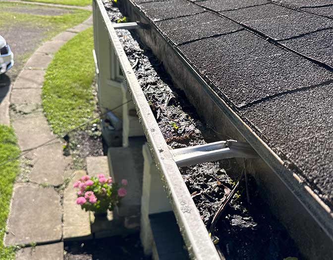 Gutter packed with debris along a roof edge found during a Columbus, Ohio home inspection
