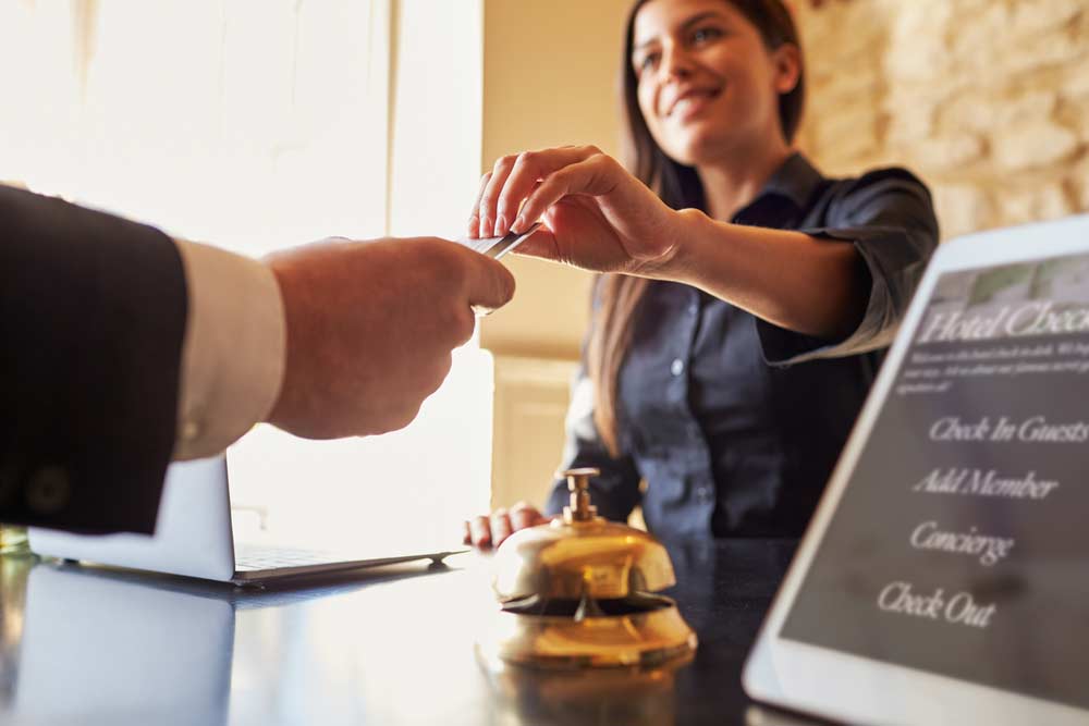 woman handing businessman a hotel room key card